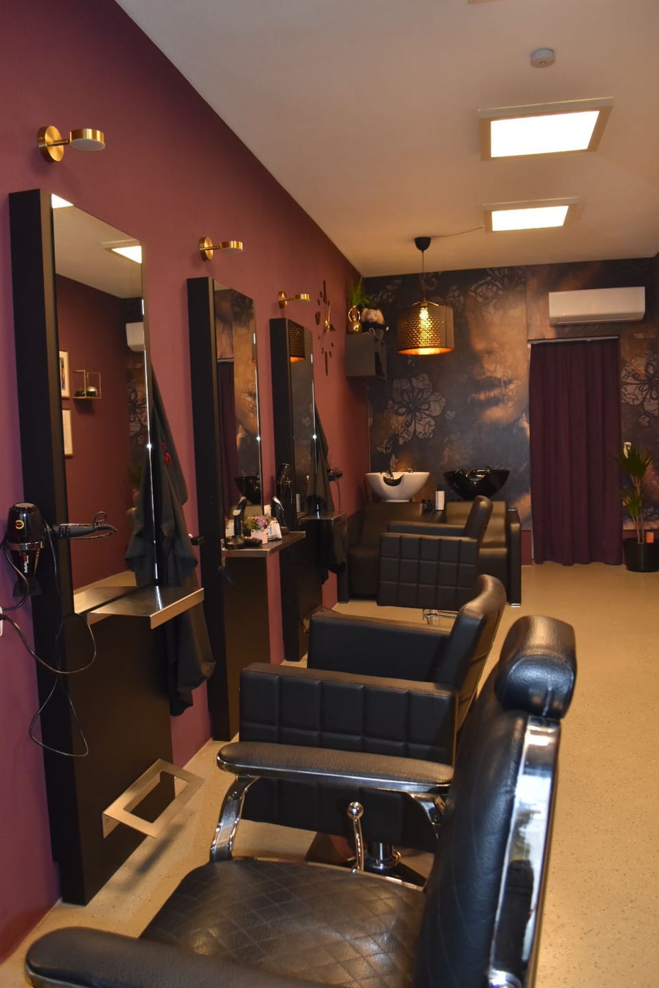 Stylingbereich mit Spiegelreihe und Friseurstühlen.