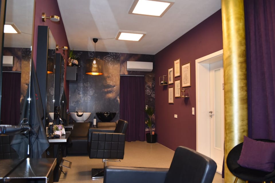 Waschplatz im Friseursalon mit dekorativer Gesichter-Tapete.